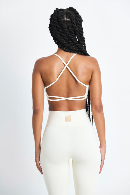 TOP AXY MACADÂMIA: Parte de trás de um conjunto esportivo feminino cor macadâmia, com top de tiras cruzadas e leggings.